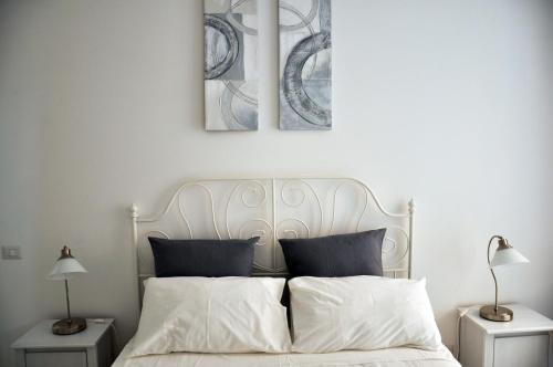 ローマにあるPetrarca n.8の白いベッド1台、壁に2枚の写真が飾られたベッドルーム1室