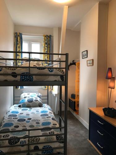 1 Schlafzimmer mit 2 Etagenbetten und einem Schreibtisch in der Unterkunft Vue mer à Arromanches in Arromanches-les-Bains