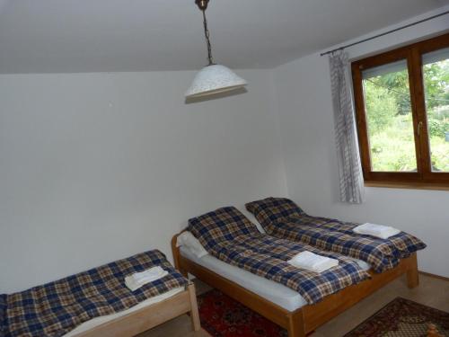 a room with two beds and a window at Gyümölcsöskert Szálláshely in Debrecen