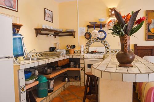 a kitchen with a vase of flowers on a counter at Hotel Casamar Suites in Puerto Escondido