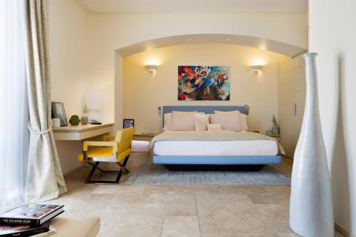 um quarto com uma cama grande e uma cadeira amarela em Hotel Villa Blu Capri em Anacapri