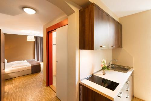 a kitchen with a sink, stove, and refrigerator at Empress Boutique Hotel in Munich