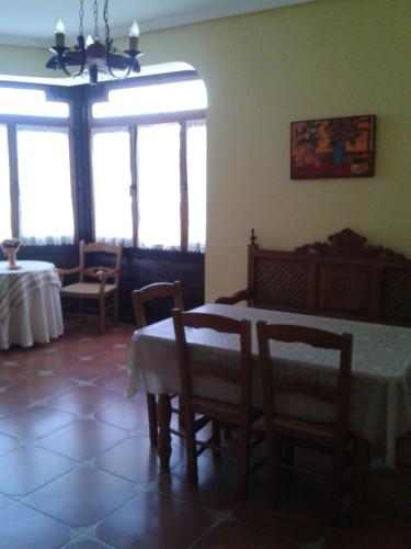 a dining room with a table and chairs and windows at El Balcón de la Mancha in Tembleque