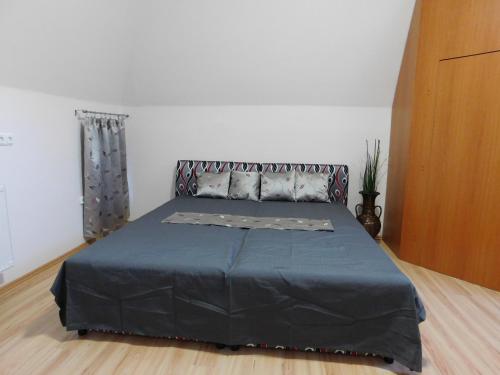 バラトンアルマーディにあるTulipán Apartmanのベッドルーム1室(青い毛布付きのベッド1台付)