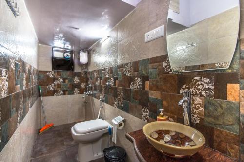 a bathroom with a toilet and a sink at Backpackers Villa Mumbai in Mumbai