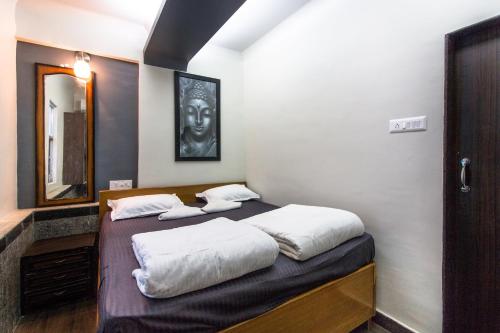a bedroom with two beds and a mirror at Backpackers Villa Mumbai in Mumbai
