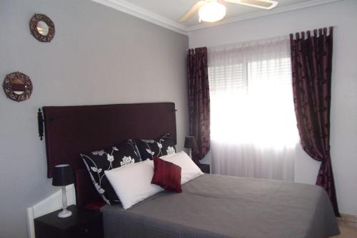 sypialnia z łóżkiem i oknem w obiekcie Apartamento El Toro w mieście Torrevieja