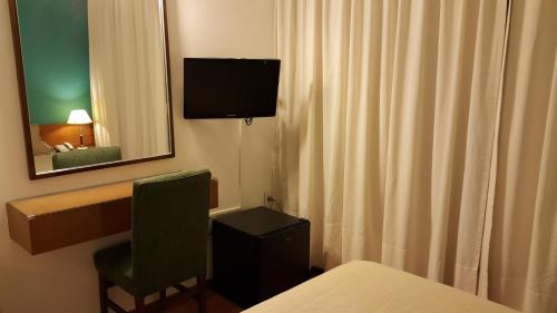 a room with a desk and a television on the wall at Hotel Avenida in Buenos Aires