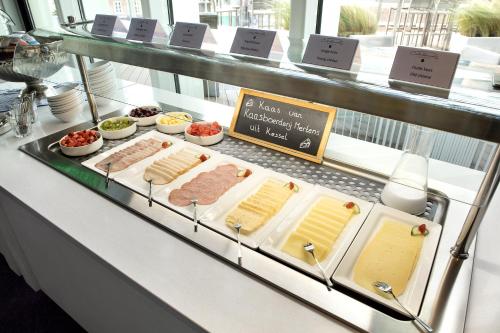 Una vitrina con quesos, carnes y otros alimentos. en Theaterhotel Venlo, en Venlo