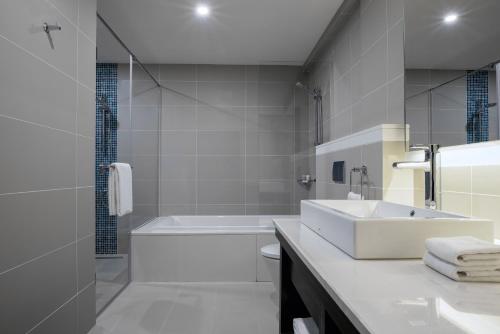 a bathroom with a sink and a tub and a toilet at The Residency Towers, Rameswaram in Rāmeswaram