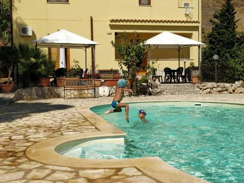 カステッランマーレ・デル・ゴルフォにあるCasa Vacanze Valentinaの子供2名がスイミングプールで遊んでいます。