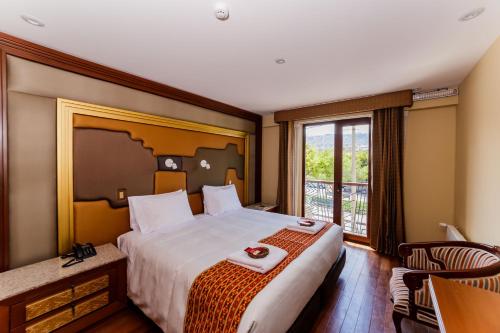 Una habitación de hotel con una cama grande y una ventana. en Yawar Inka Hotel, en Cusco
