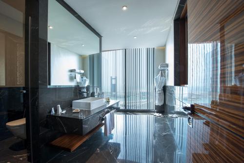 マナーマにあるFraser Suites Diplomatic Area Bahrainの洗面台と大きな窓のあるバスルーム