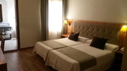 a bedroom with a large bed in a hotel room at Hotel Sierra Las Villas in Villacarrillo