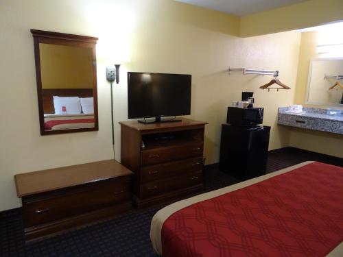 a hotel room with a bed and a flat screen tv at Econo Lodge Fredericksburg near I-95 in Fredericksburg