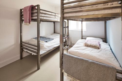 two bunk beds in a room with a bed at The Barrel Store Cirencester in Cirencester