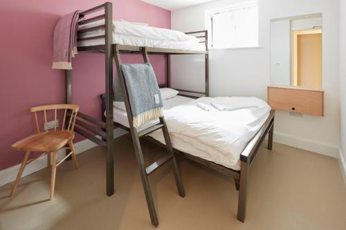a bunk bed room with a bed and a chair at The Barrel Store Cirencester in Cirencester