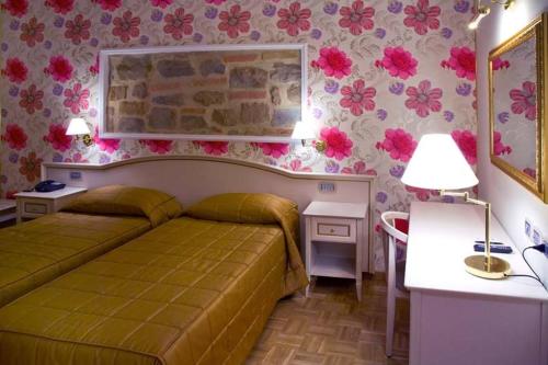 a bedroom with a bed and flowers on the wall at Relais Villa Fornari in Camerino