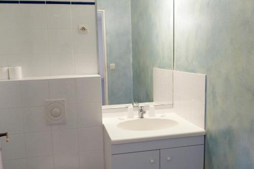 a white bathroom with a sink and a mirror at VTF Les Florans in Bédoin