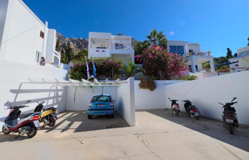 a group of motorcycles parked next to a white wall at Tatsis Apartments in Masouri