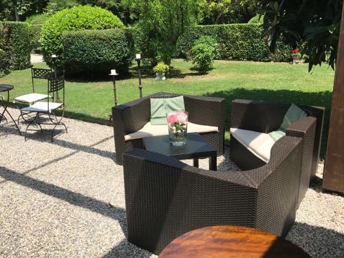 a patio with wicker chairs and a table with flowers at Cà Sagredo in Conselve