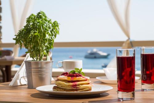 een bord pannenkoeken op een tafel met twee drankjes bij Anamar Kea Boutique in Koundouros