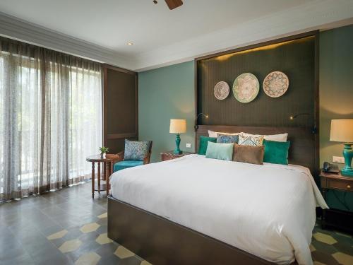 a bedroom with a large bed and a large window at AIRA Boutique Hoi An Hotel & Villa in Hoi An