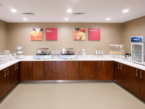 a large kitchen with brown cabinets and white counter tops at Comfort Suites Piedmont - Greenville South in Piedmont