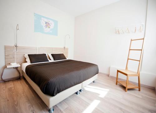 sypialnia z dużym łóżkiem i krzesłem w obiekcie B&B Lo Studio w mieście LʼAquila