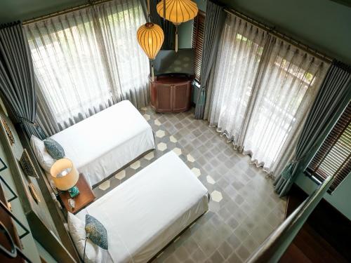 an overhead view of a room with two beds and windows at AIRA Boutique Hoi An Hotel & Villa in Hoi An