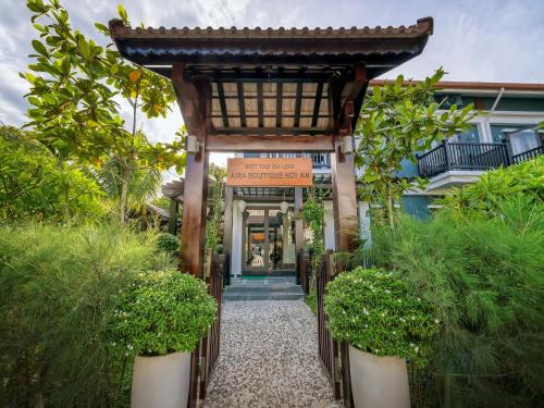 an entrance to a building with a gate and plants at AIRA Boutique Hoi An Hotel & Villa in Hoi An
