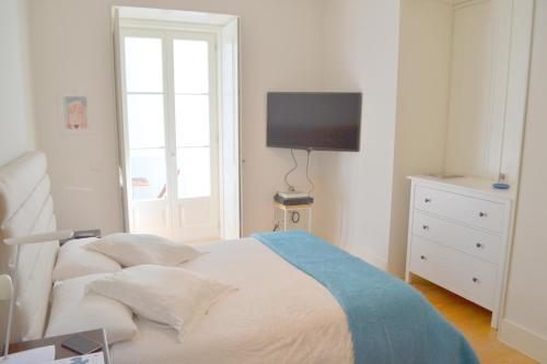 a bedroom with a bed with a tv on the wall at TP Maestro 74, Lisbon Luxury & Swimming Pool in Lisbon
