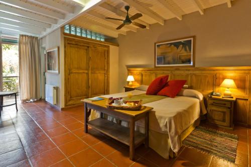 1 dormitorio con 1 cama grande y 1 mesa en La Hostería Cariló Hotel Spa en Cariló