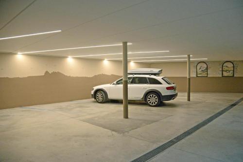 a white car parked in a parking garage at Apartment Sella in Siusi
