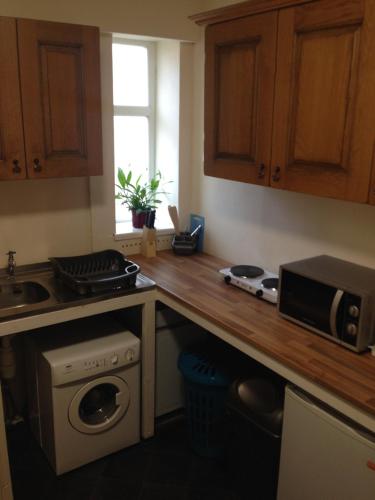 a kitchen with a sink and a stove top oven at Yado Hotel in Blackpool