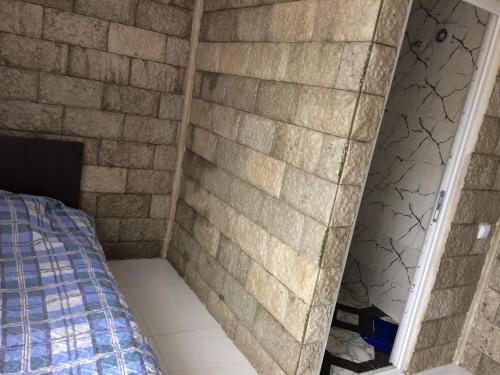 a room with a brick wall and a bed at House near The Black Sea in Makhinjauri