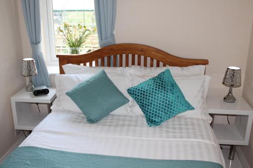 a bed with two blue pillows on it with a window at Magnolia Self Contained Suites in Bristol