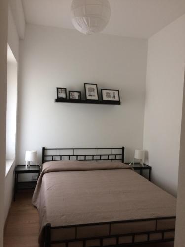 a bedroom with a bed and two pictures on the wall at La Porta Nel Giardino in Asti