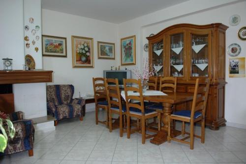 a dining room with a wooden table and chairs at B&B Ida in Oristano
