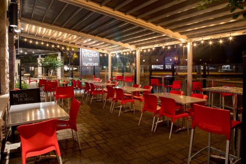 a restaurant with tables and chairs and lights at Hotel V in Gatineau