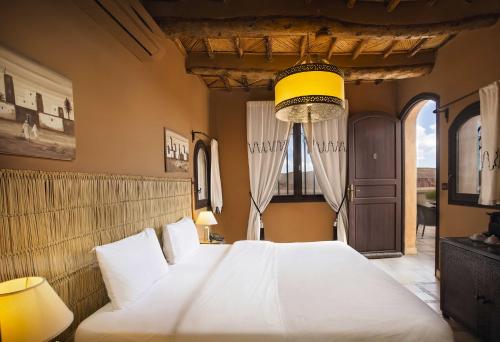 a bedroom with a large white bed in a room at Ksar Ighnda in Aït Ben Haddou