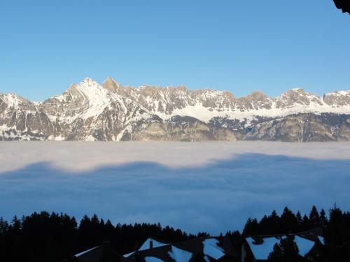 a view of a snow covered mountain range with a lake at Hotel Tannenboden in Flumserberg