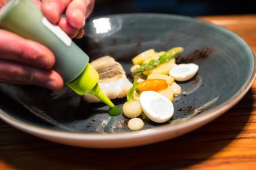 a person is cutting eggs on a plate with a knife at Pousada de Bragança - Sao Bartolomeu in Bragança