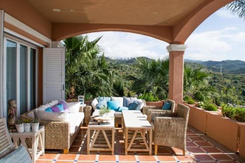 an outdoor patio with wicker furniture and a table and chairs at The Marbella Heights Boutique Hotel in Marbella