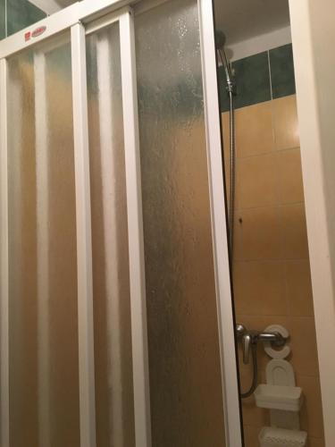 a shower door in a bathroom with a toilet at Penzion Partizan in Smokovce
