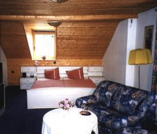 a bedroom with a bed and a table and a couch at Landgasthof Klippermühle in Tharandt