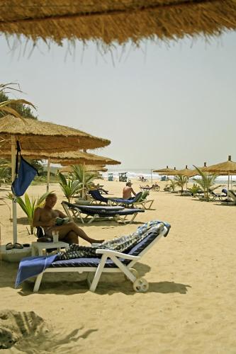 a group of people sitting on the beach at The Kairaba Beach Hotel in Kololi