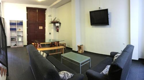 a living room with a couch and a table and a tv at Casa Rural Xàtiva in Xàtiva