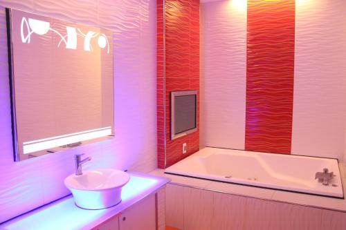 a bathroom with a sink and a bath tub at Kai-Hong Motel in Longtan