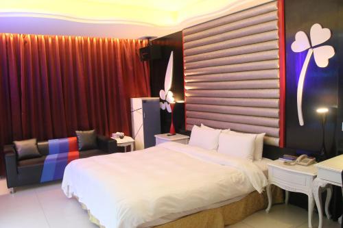a bedroom with a bed and a desk and a chair at Kai-Hong Motel in Longtan